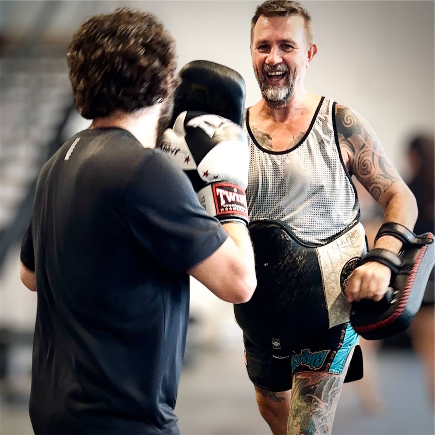 Carl smiling as he coaches a member on the pads
