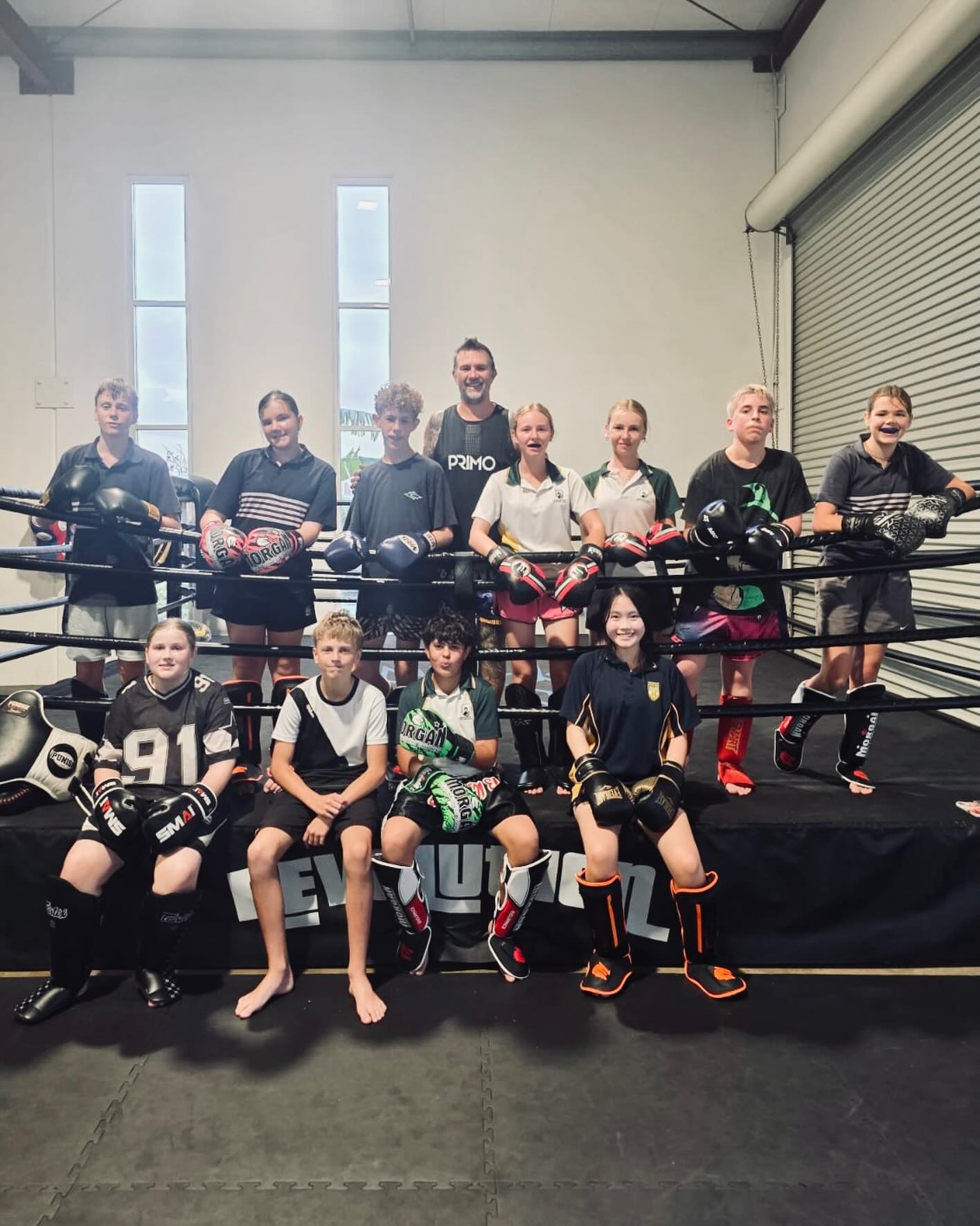Teen members with their coach in the Revolution ring
